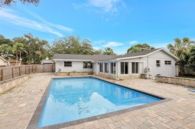 rear view of house featuring a patio and a fenced in pool