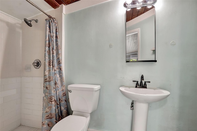 bathroom featuring toilet and a shower with curtain