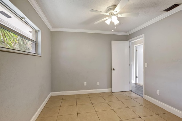 unfurnished room featuring ornamental molding, a textured ceiling, light tile patterned floors, and ceiling fan