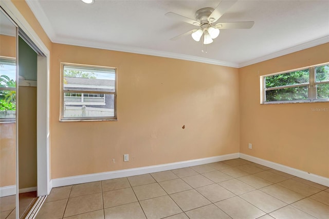 spare room featuring ornamental molding, light tile patterned floors, and ceiling fan