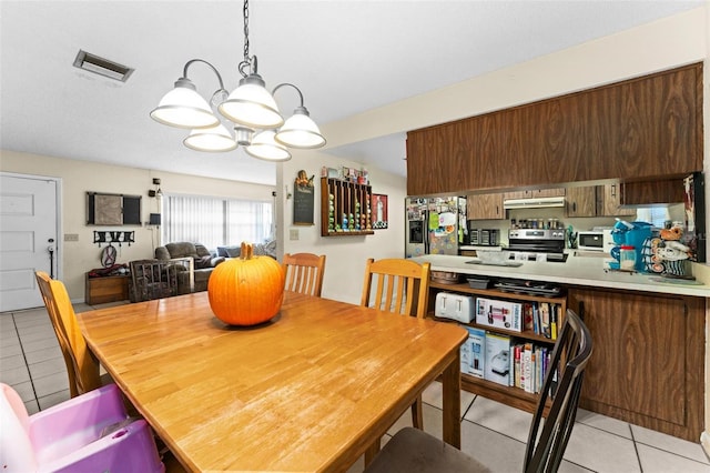 tiled dining space featuring an inviting chandelier