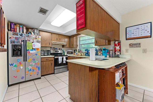 kitchen featuring ventilation hood, kitchen peninsula, light tile patterned floors, and stainless steel appliances