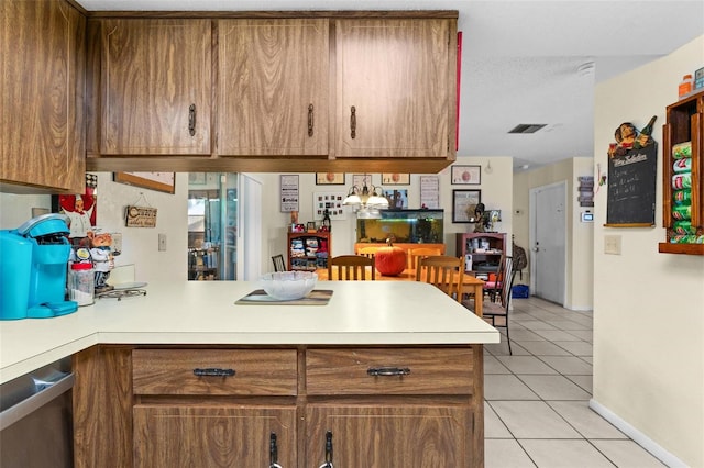 kitchen with dishwasher, kitchen peninsula, a textured ceiling, and light tile patterned floors