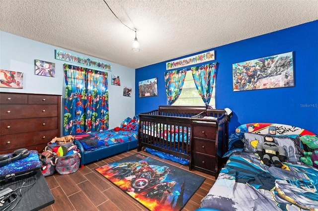 bedroom with dark wood-type flooring and a textured ceiling