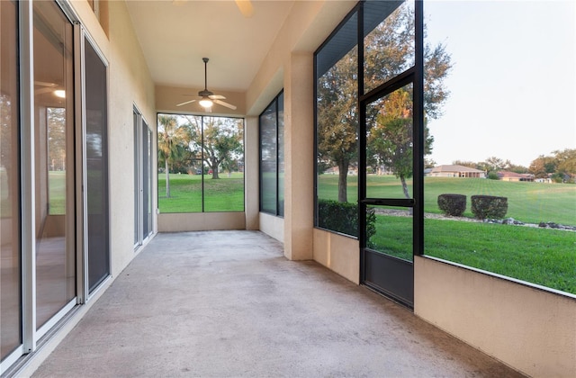 unfurnished sunroom with ceiling fan