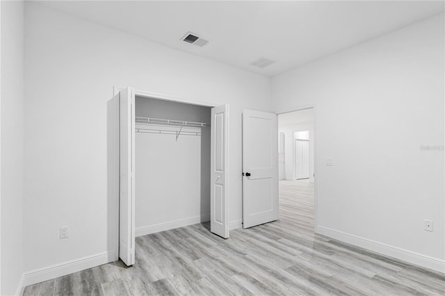 unfurnished bedroom featuring a closet and light hardwood / wood-style flooring