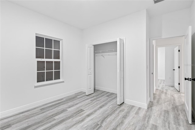 unfurnished bedroom featuring a closet and light hardwood / wood-style floors