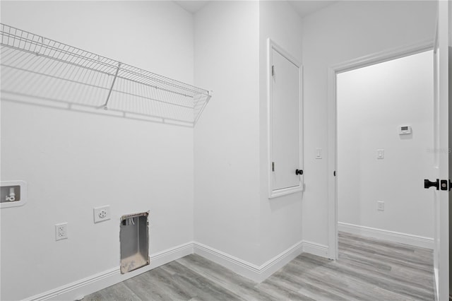 clothes washing area with hookup for an electric dryer, hookup for a washing machine, and light wood-type flooring