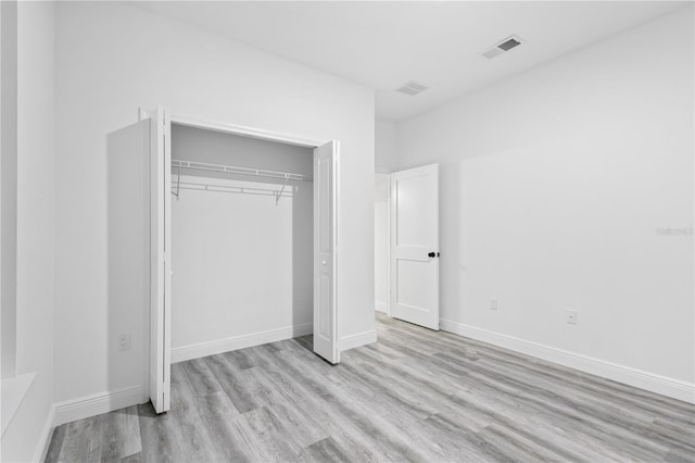 unfurnished bedroom featuring a closet and light wood-type flooring