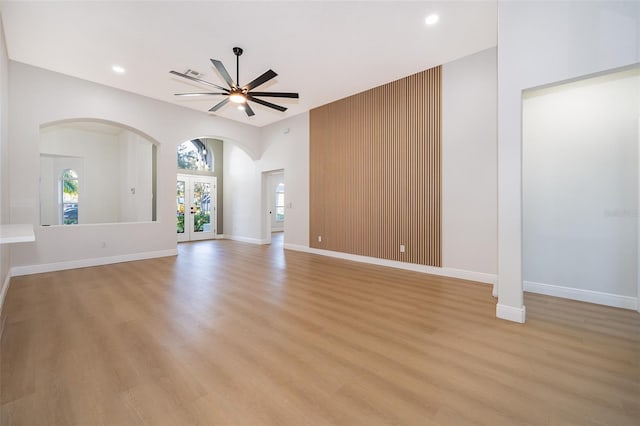 unfurnished living room with french doors, light wood-type flooring, and ceiling fan