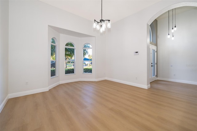 empty room featuring light hardwood / wood-style flooring and an inviting chandelier