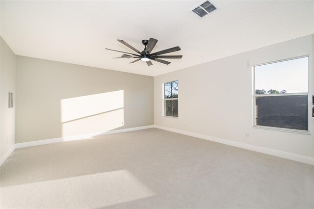 empty room with ceiling fan and light colored carpet