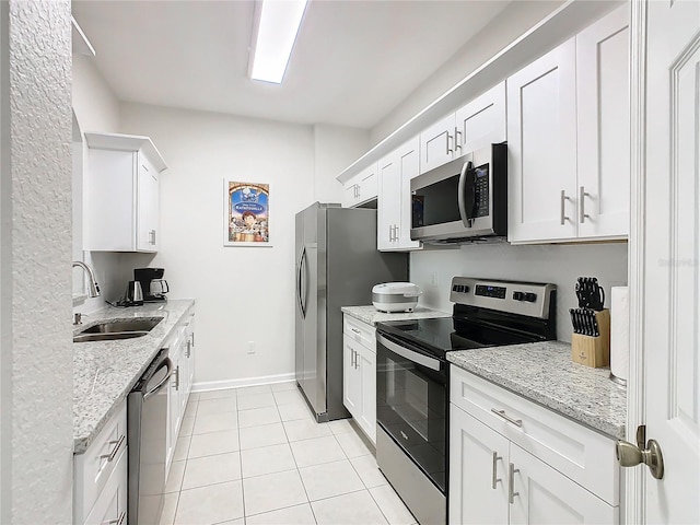 kitchen featuring light stone counters, stainless steel appliances, sink, and white cabinets