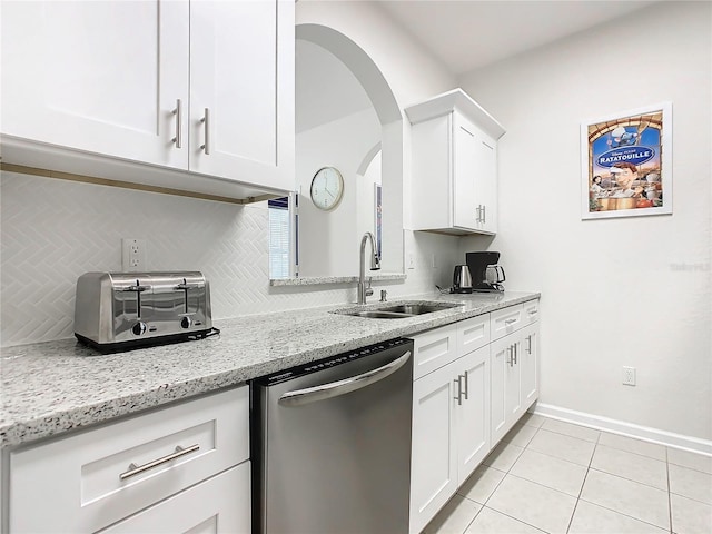 kitchen with light stone countertops, sink, stainless steel dishwasher, and white cabinets