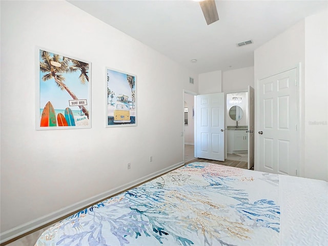 bedroom featuring ensuite bath, wood-type flooring, and ceiling fan