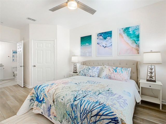 bedroom featuring connected bathroom, wood-type flooring, and ceiling fan