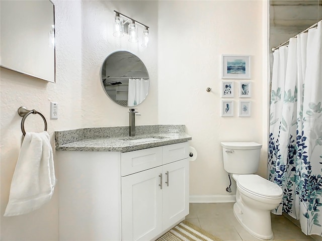 bathroom featuring toilet, vanity, and tile patterned flooring