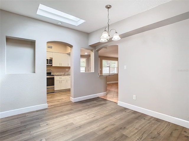 unfurnished dining area with light hardwood / wood-style flooring and an inviting chandelier