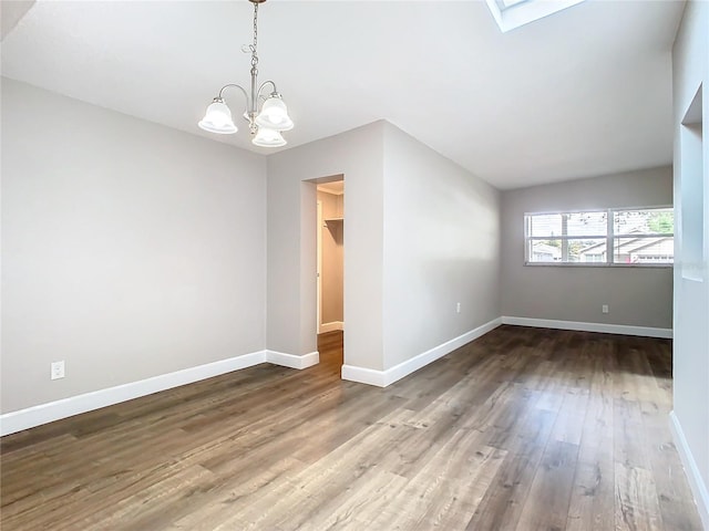 unfurnished room with a chandelier, wood-type flooring, and a skylight