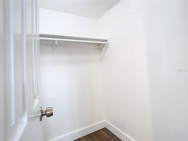 walk in closet with dark wood-type flooring