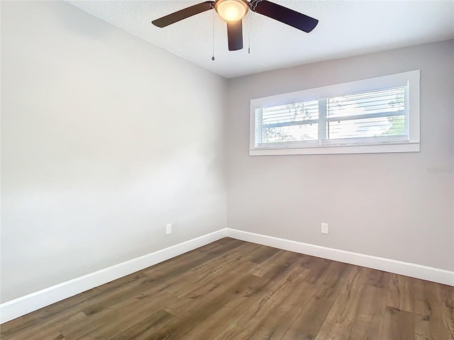 empty room with ceiling fan and dark hardwood / wood-style flooring