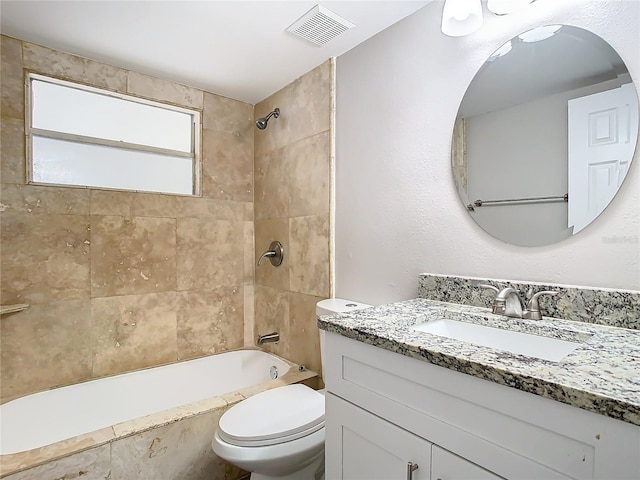 full bathroom with toilet, tiled shower / bath, and vanity