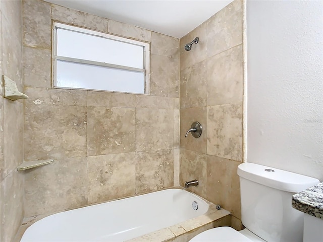 bathroom featuring toilet and tiled shower / bath combo