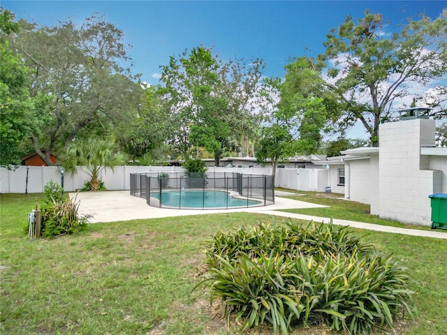 view of pool with a patio and a lawn