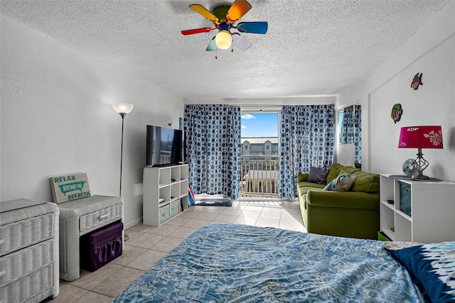 bedroom featuring ceiling fan, light tile patterned flooring, a textured ceiling, and access to outside