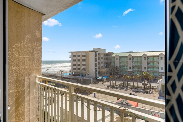 balcony with a water view and a beach view