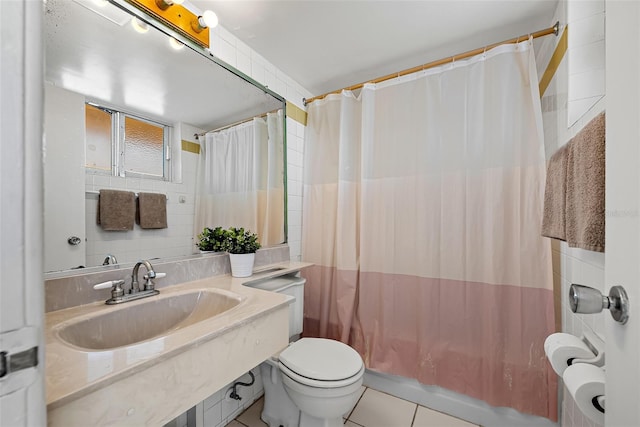 full bathroom with sink, tile patterned flooring, toilet, shower / tub combo with curtain, and tile walls