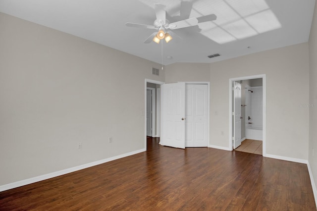 unfurnished bedroom featuring wood-type flooring, a closet, ceiling fan, and ensuite bathroom