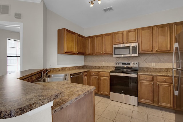 kitchen with sink, decorative backsplash, stainless steel appliances, and kitchen peninsula