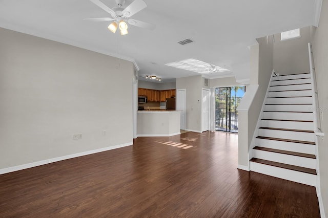 unfurnished living room featuring dark wood-type flooring, ornamental molding, and ceiling fan