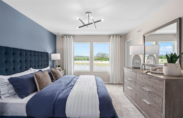 carpeted bedroom featuring a notable chandelier and a textured ceiling