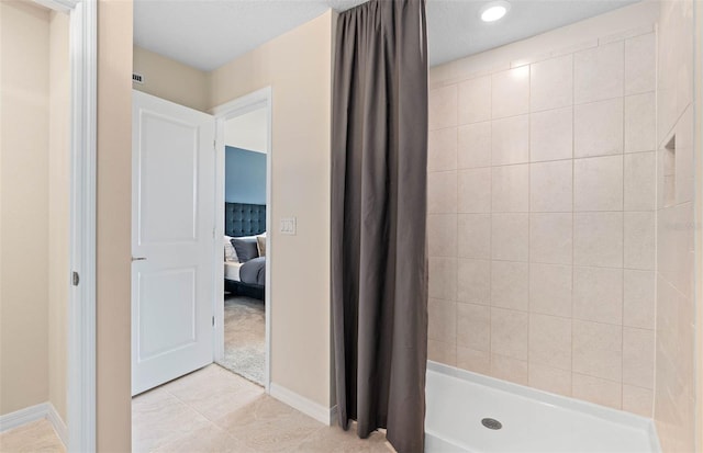 bathroom with tile patterned flooring and walk in shower