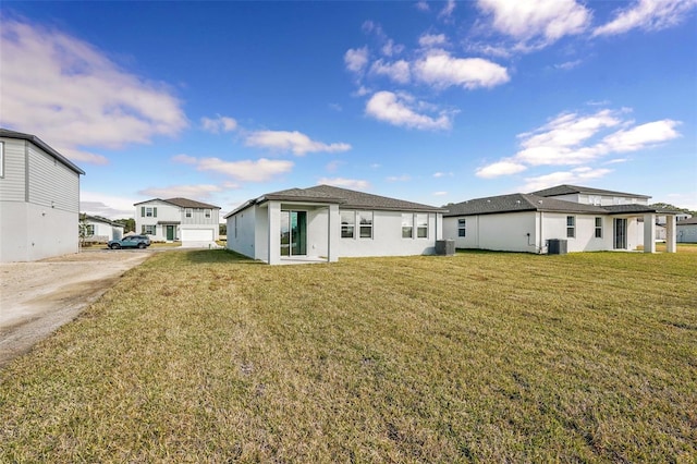 rear view of property with a lawn and central air condition unit