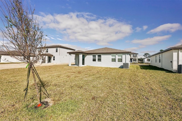 rear view of house featuring a lawn and central air condition unit