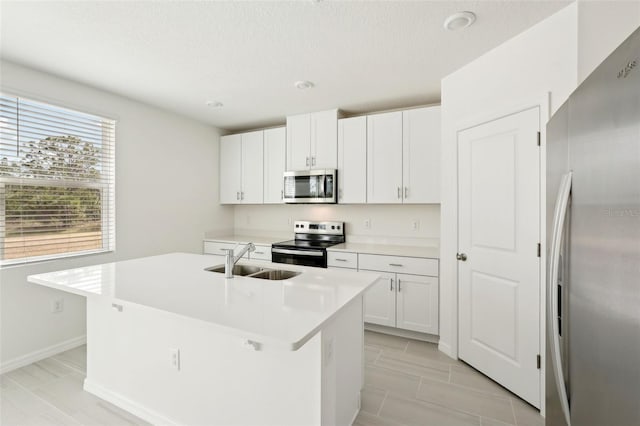 kitchen featuring white cabinetry, a kitchen island with sink, sink, and appliances with stainless steel finishes