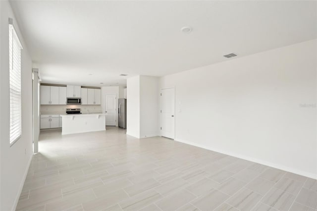 unfurnished living room featuring light tile patterned floors