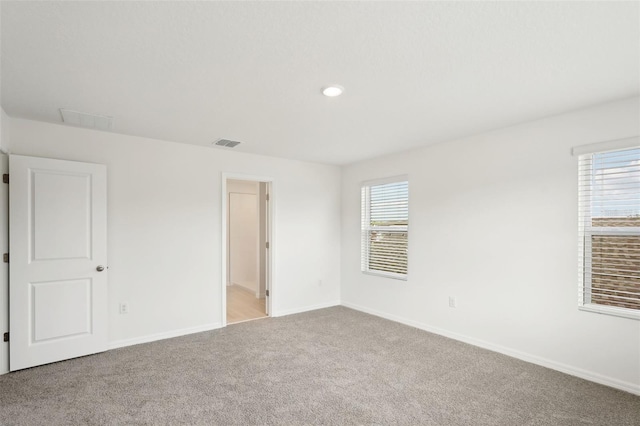 unfurnished room featuring light colored carpet