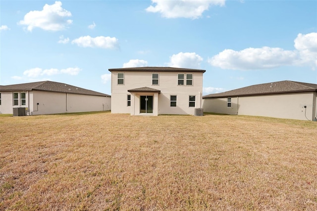 rear view of property with a yard and central AC