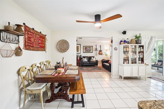 tiled dining space featuring ceiling fan