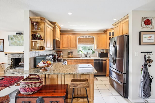 kitchen featuring kitchen peninsula, tasteful backsplash, a breakfast bar, sink, and stainless steel appliances