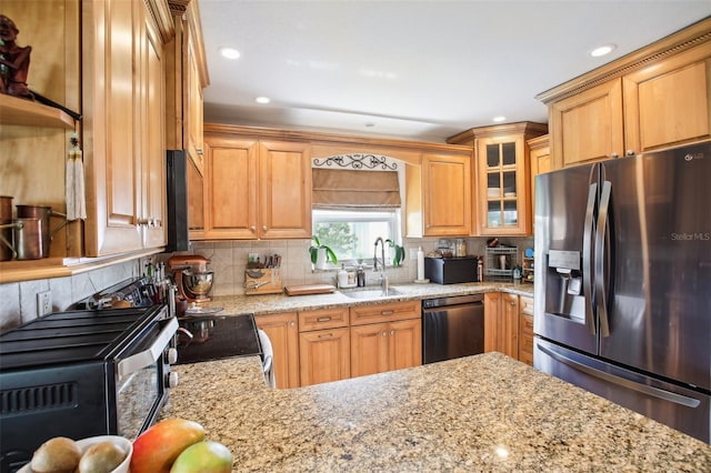 kitchen featuring sink, black appliances, light stone counters, and tasteful backsplash