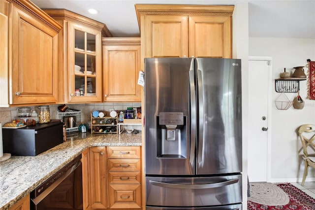 kitchen featuring decorative backsplash, stainless steel fridge, light stone countertops, dishwasher, and tile patterned flooring