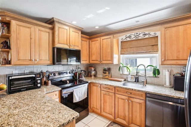 kitchen featuring light stone countertops, sink, backsplash, stainless steel appliances, and light tile patterned floors