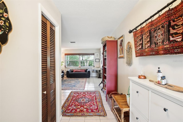 hall with light tile patterned floors