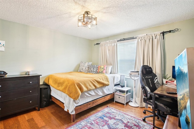 bedroom featuring wood-type flooring and a textured ceiling