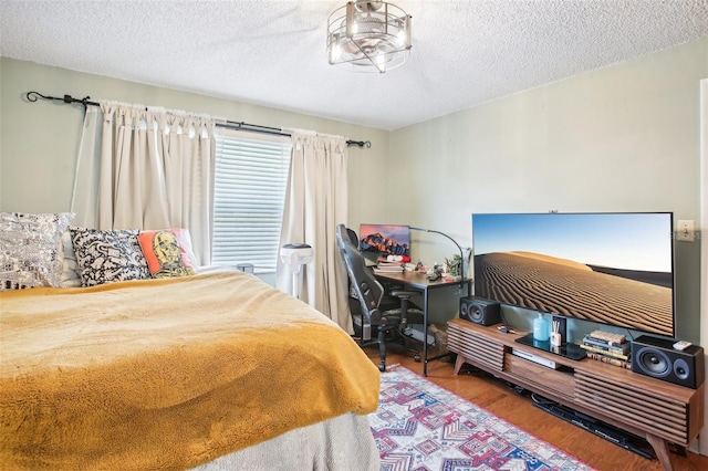 bedroom with a textured ceiling and hardwood / wood-style floors